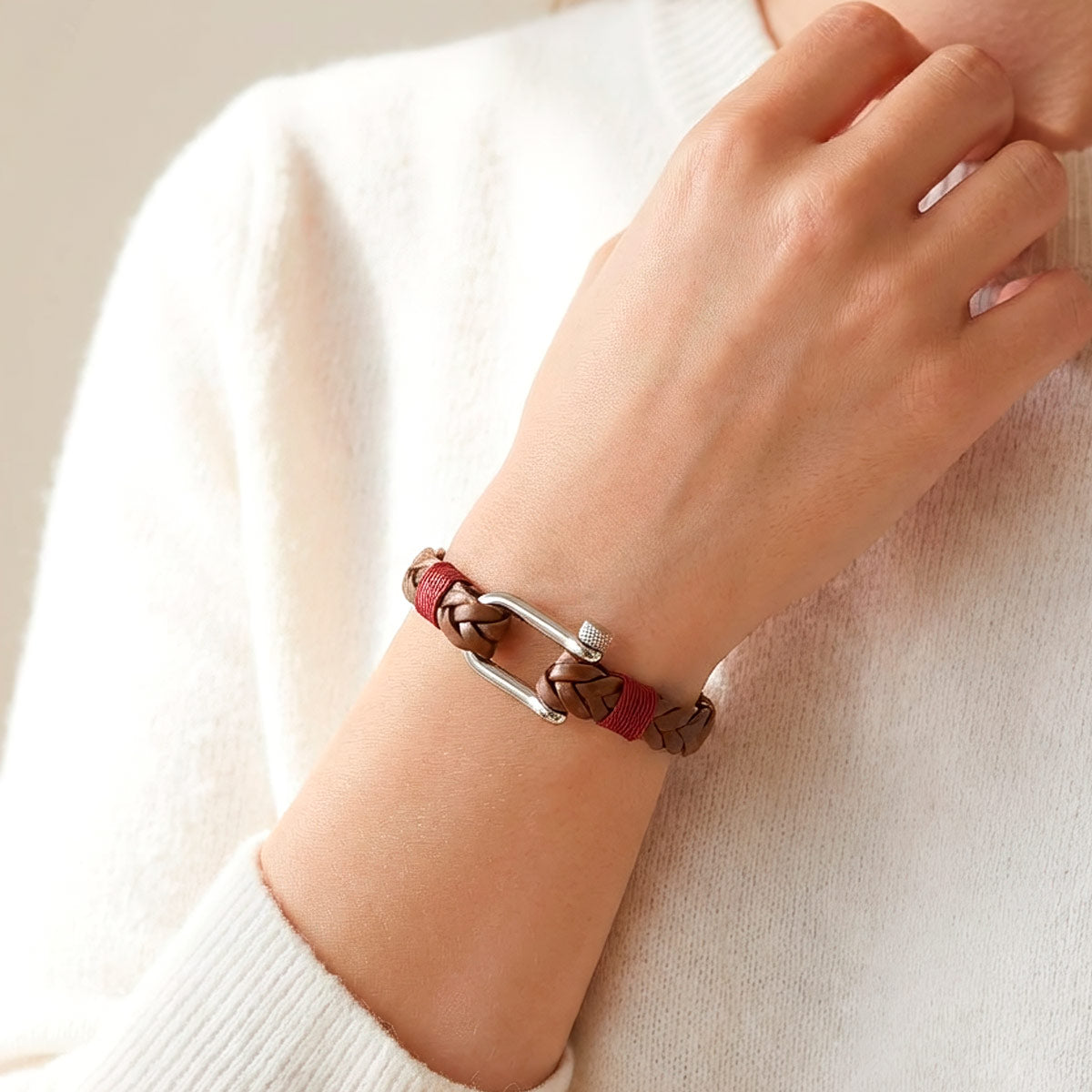 Ruskea nahkarannekoru mallin kädessä