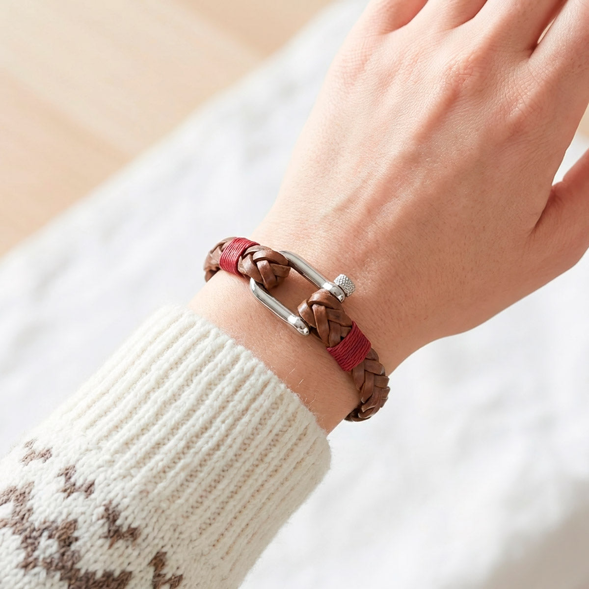 Ruskea nahkarannekoru mallin kädessä