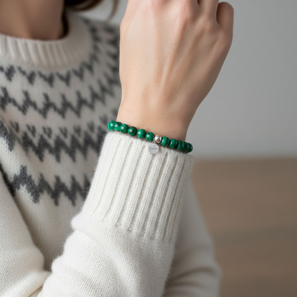Kauniin vihreä aito malakiitti rannekoru naisen kädessä | Taika-korut