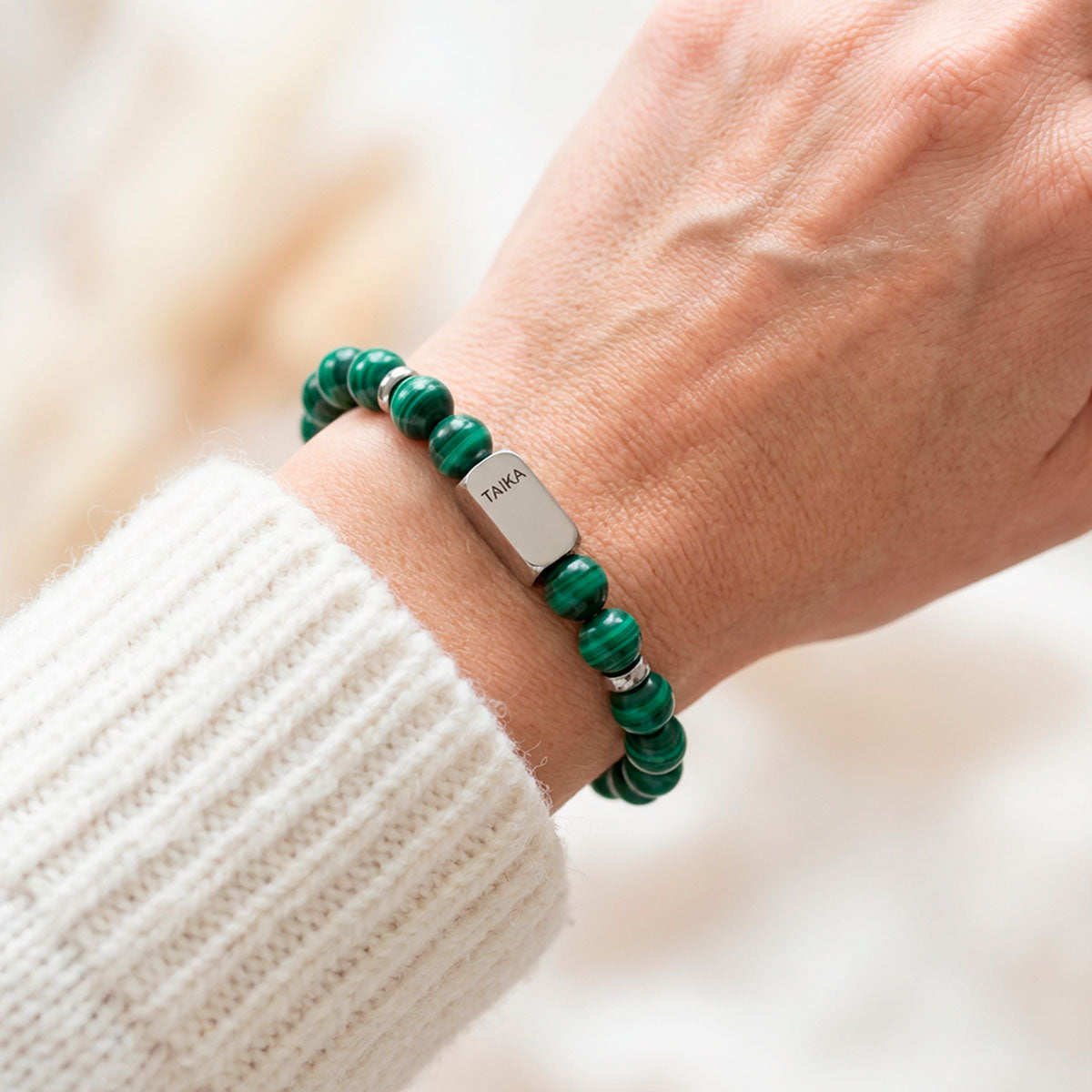 Vihreä malakiitti rannekoru naisen kädessä