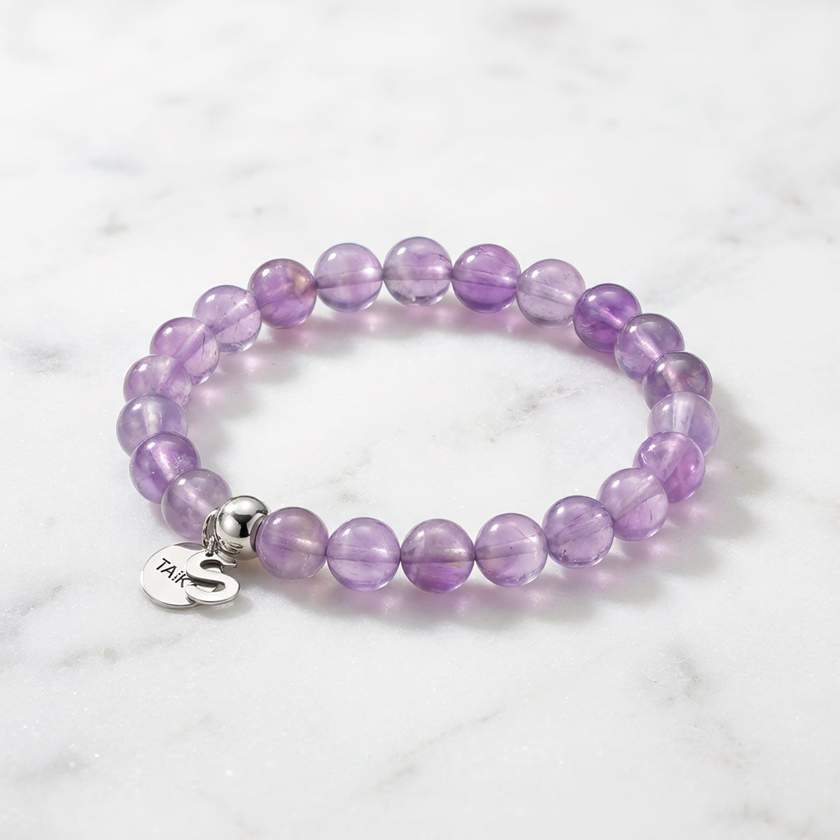 Violetti aito ametisti rannekoru pöydällä 