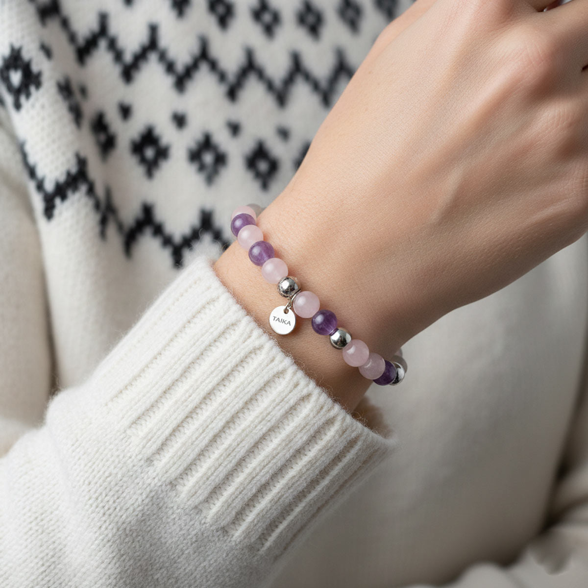 Vaaleanpunainen hempeä harmonia kivirannekoru naisen kädessä