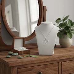 Hopeinen elämänpuu kaulakoru pöydällä