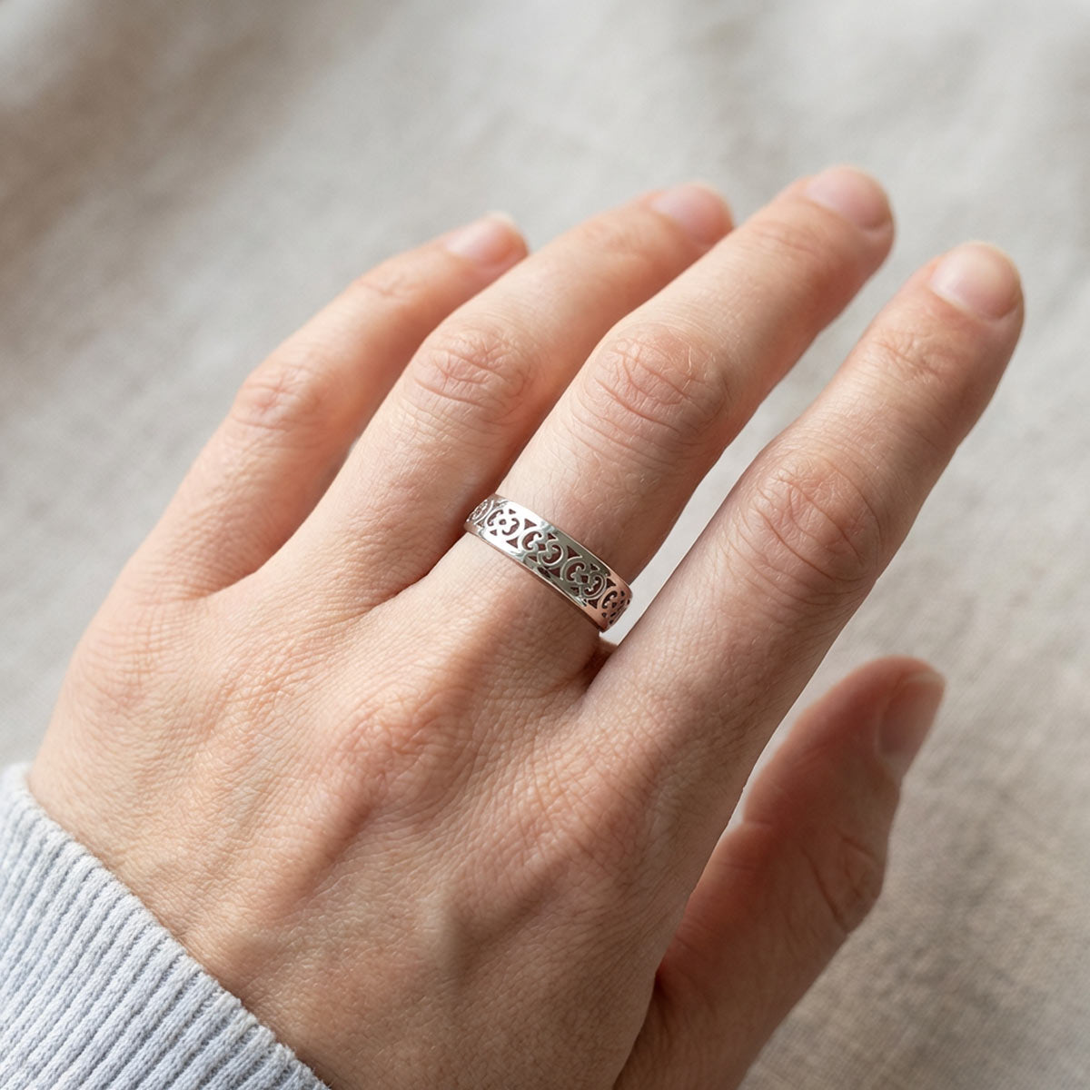 Hopeinen filigraanisormus naisen kädessä