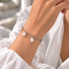 Silver paperclip bracelet with six pearl charms on a model's wrist, PER-4002-H