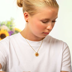 Kullattu Aurinko hopeakaulakoru mallin päällä
