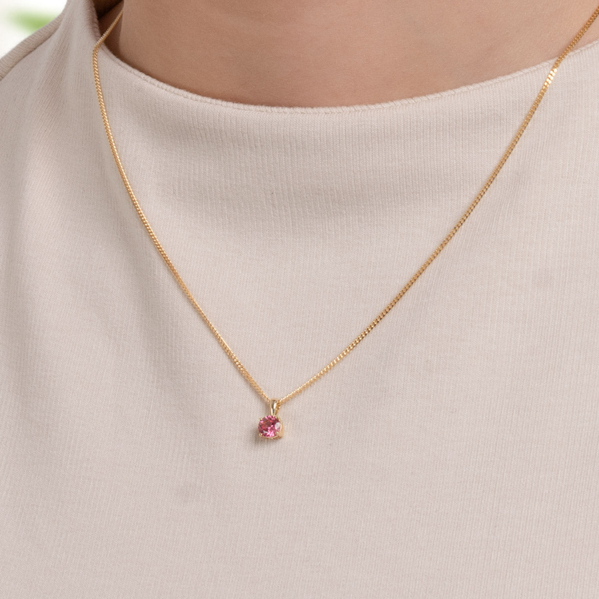 Close-up of a small gold tourmaline pendant worn by a model, PRE4002-tur