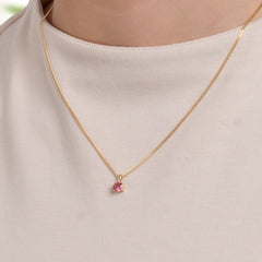 Close-up of a small gold tourmaline pendant worn by a model, PRE4002-tur