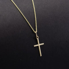 Small gold cross pendant on a dark background, IBBLK216
