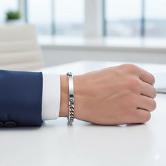 Teräsrannekoru kaiverrettava kädessä