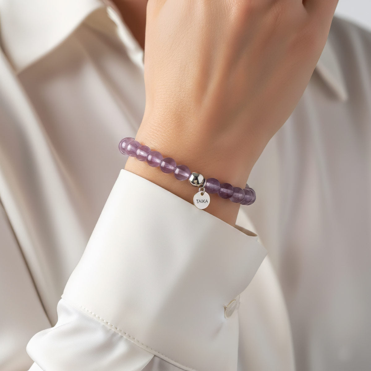 Violetti ametisti rannekoru naisen kädessä